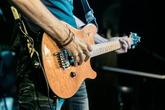 Guitarist performing live on stage under concert lighting