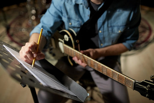 Guitarist writing a riff on an electric guitar in a rehearsal room